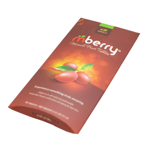 mberry Miracle Berry Tablets. Maroon with 3 miracle fruit on the front with yellow orange background. Logo has a red m and two green leaves above, followed by white letters that spell out berry.  The packaging is laying at a tilt, as if laying on a table 